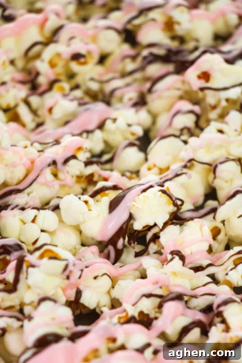 Popcorn drizzled with melted chocolate on a baking sheet