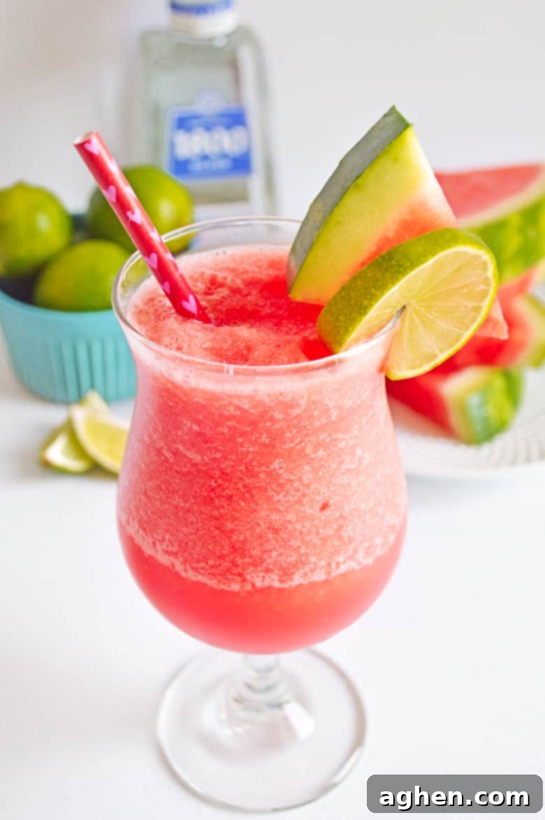 Frozen Watermelon Margarita garnished with a fresh watermelon slice and a lime slice, ready to be enjoyed.