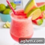 Frozen Watermelon Margarita garnished with watermelon slice and lime slice, ready for a photo share.