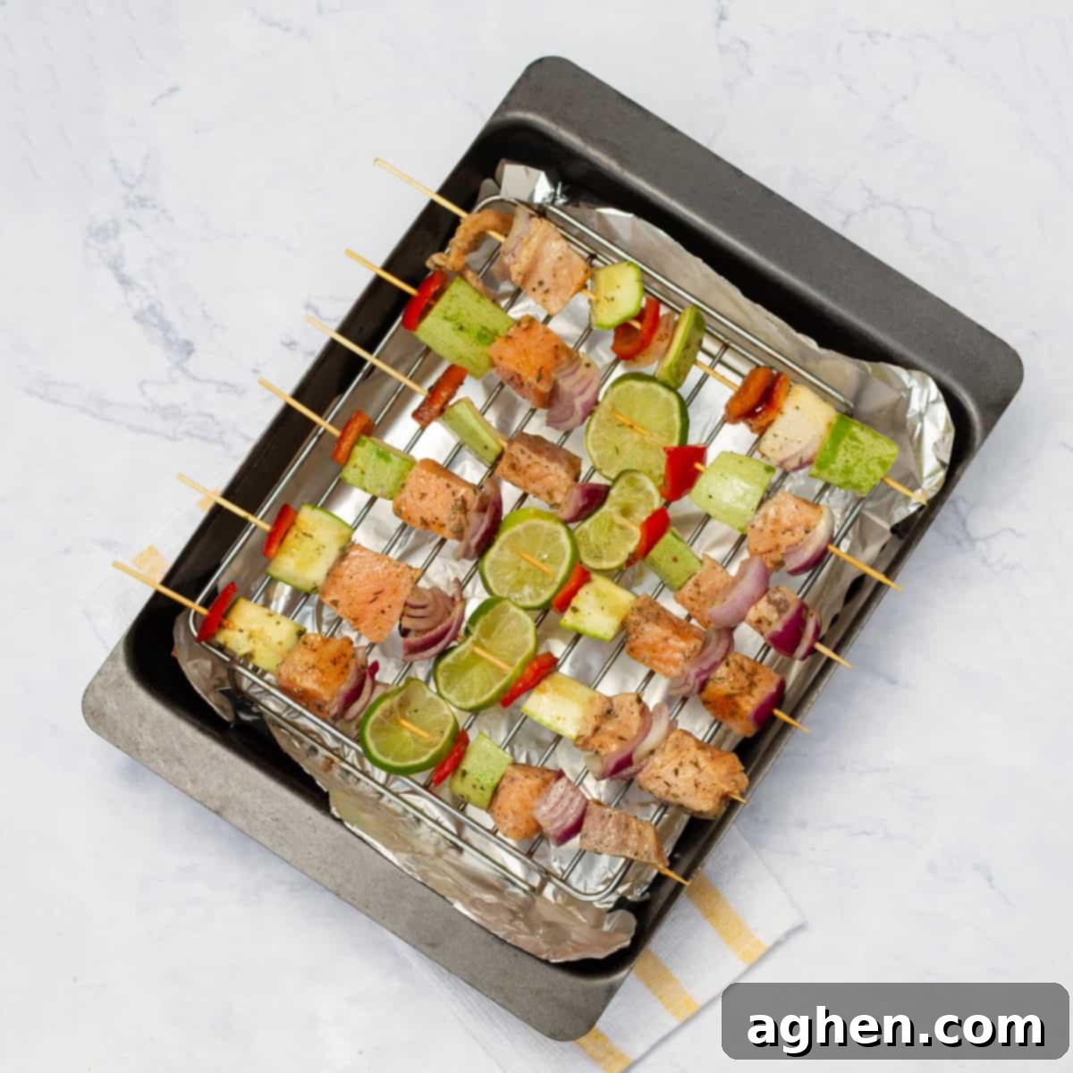 Zesty Herb Salmon Skewers 7 Salmon skewers arranged on a baking tray for grilling