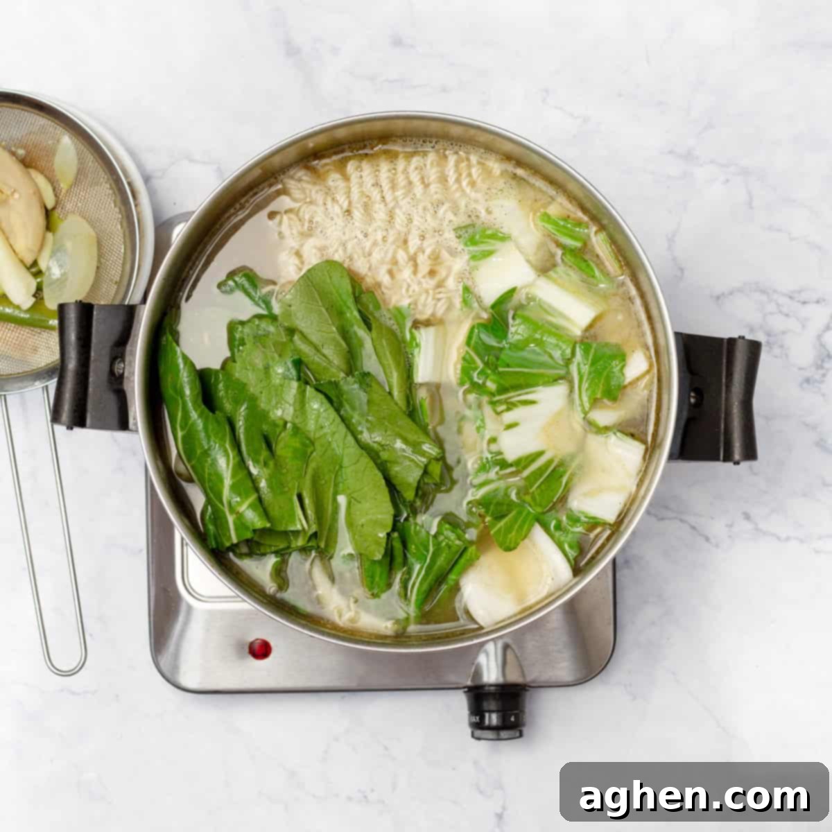 Light & Flavorful Asian Chicken Soup A Modern Take 6 Strained Asian Chicken Soup broth in a pot with cooked noodles added