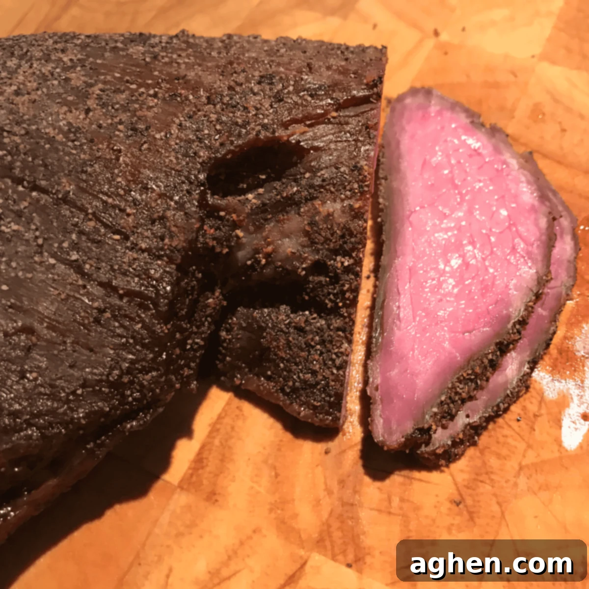smoked tri tip sitting on wooden cutting board