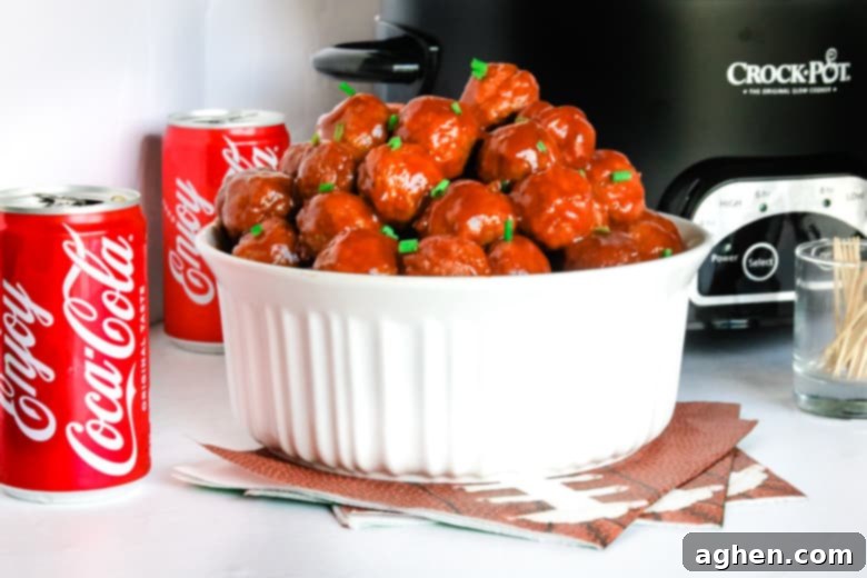 Coca-Cola Meatballs in white bowl with Crockpot and Coke cans
