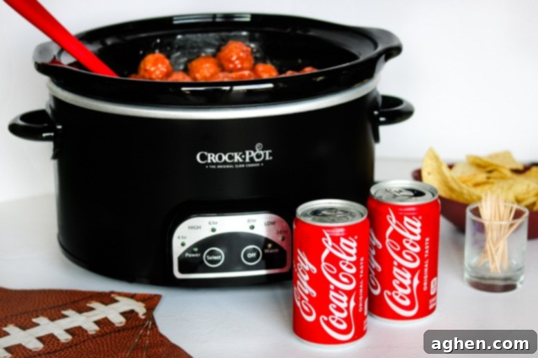 Crockpot Meatballs with Coca-Cola served in crockpot with cans of coke and chips