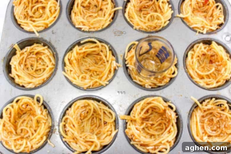 Shot glass pressed into spaghetti cup to create a well for the meatball