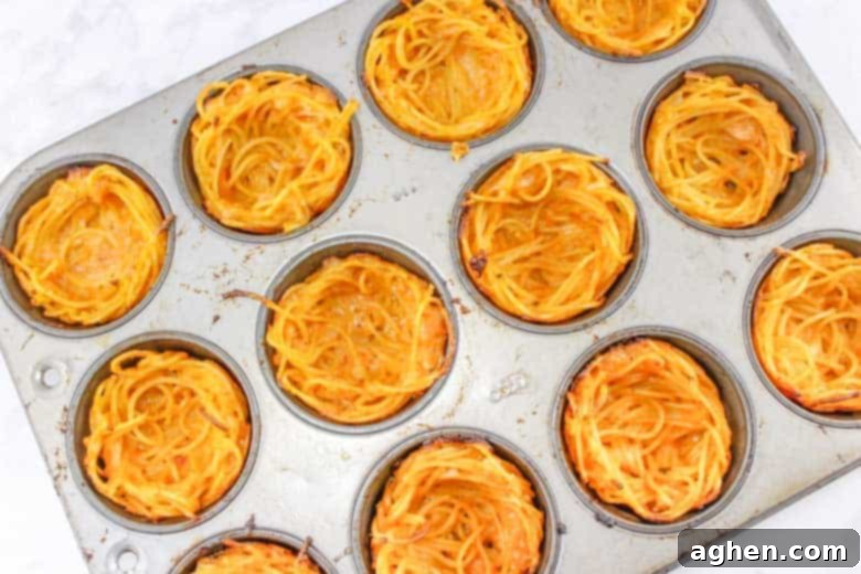 baked spaghetti cups in muffin tin, ready for assembly