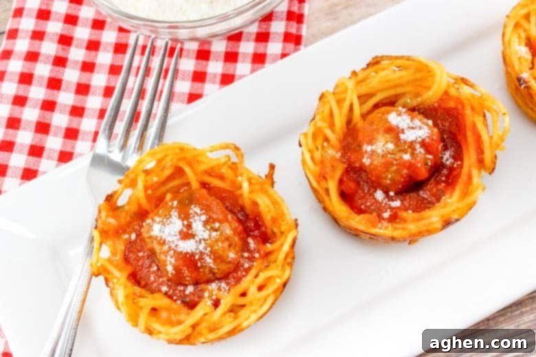 baked pasta cups with marinara and meatballs, garnished with cheese