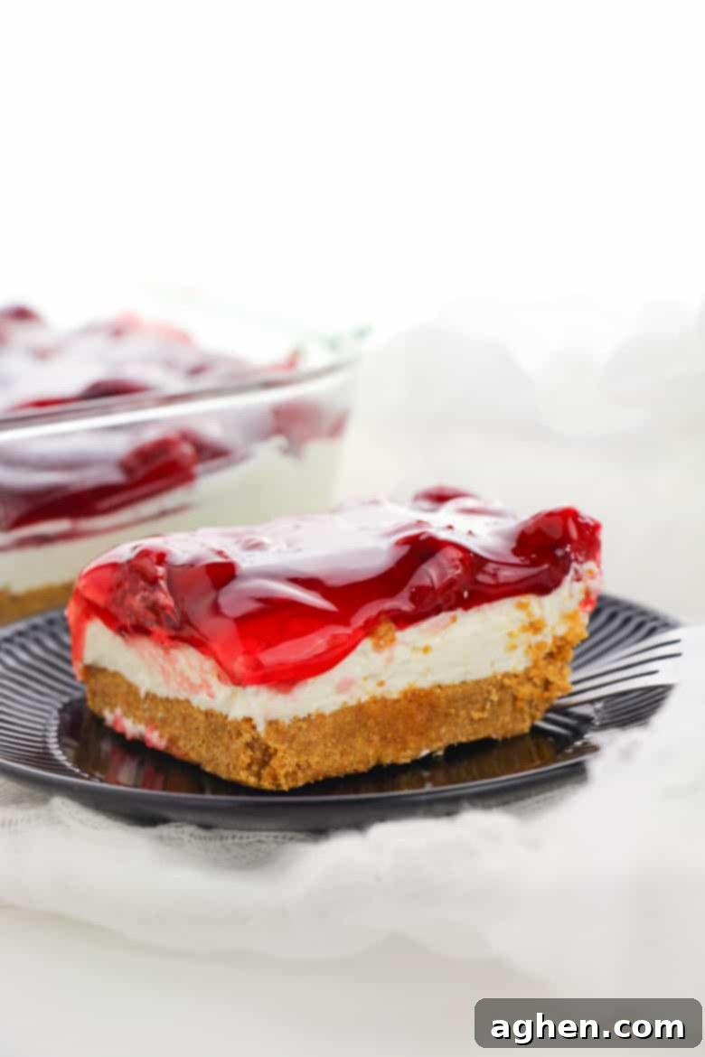 Close up of a whole No Bake Cherry Cheesecake with a spoon taking a scoop