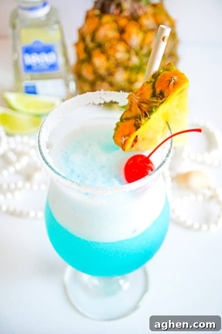 Close-up of a vibrant Frozen Blue Margarita with a lime and cherry garnish