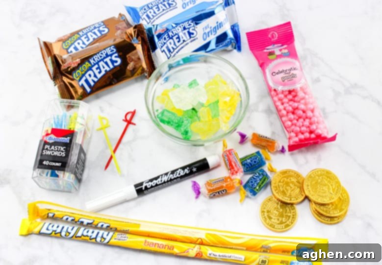 Ingredients laid out for edible pirate treasure chests: Rice Krispies Treats, Cocoa Krispies Treats, Laffy Taffy Rope, Rock Candy, Candy Pearls, Jolly Ranchers, Gold Coins, Edible Pen, and Toy swords.