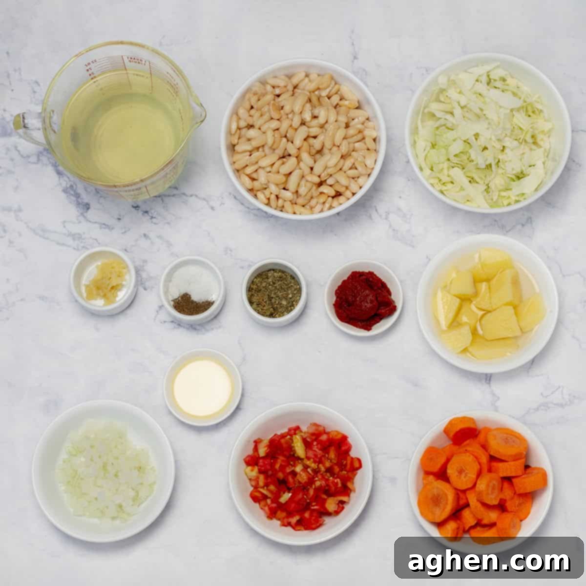 Cabbage Soup: Weight Watchers' Enduring Slimming Secret 3 Cabbage soup ingredients laid out: broth, white beans, chopped cabbage, onion, garlic, potatoes, carrots, oil, oregano, and spices.