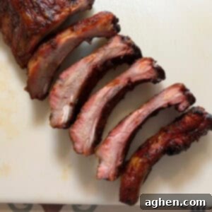 Award Winning Smoked Baby Back Ribs 16 Sliced smoked baby back ribs on a cutting board, ready for serving.