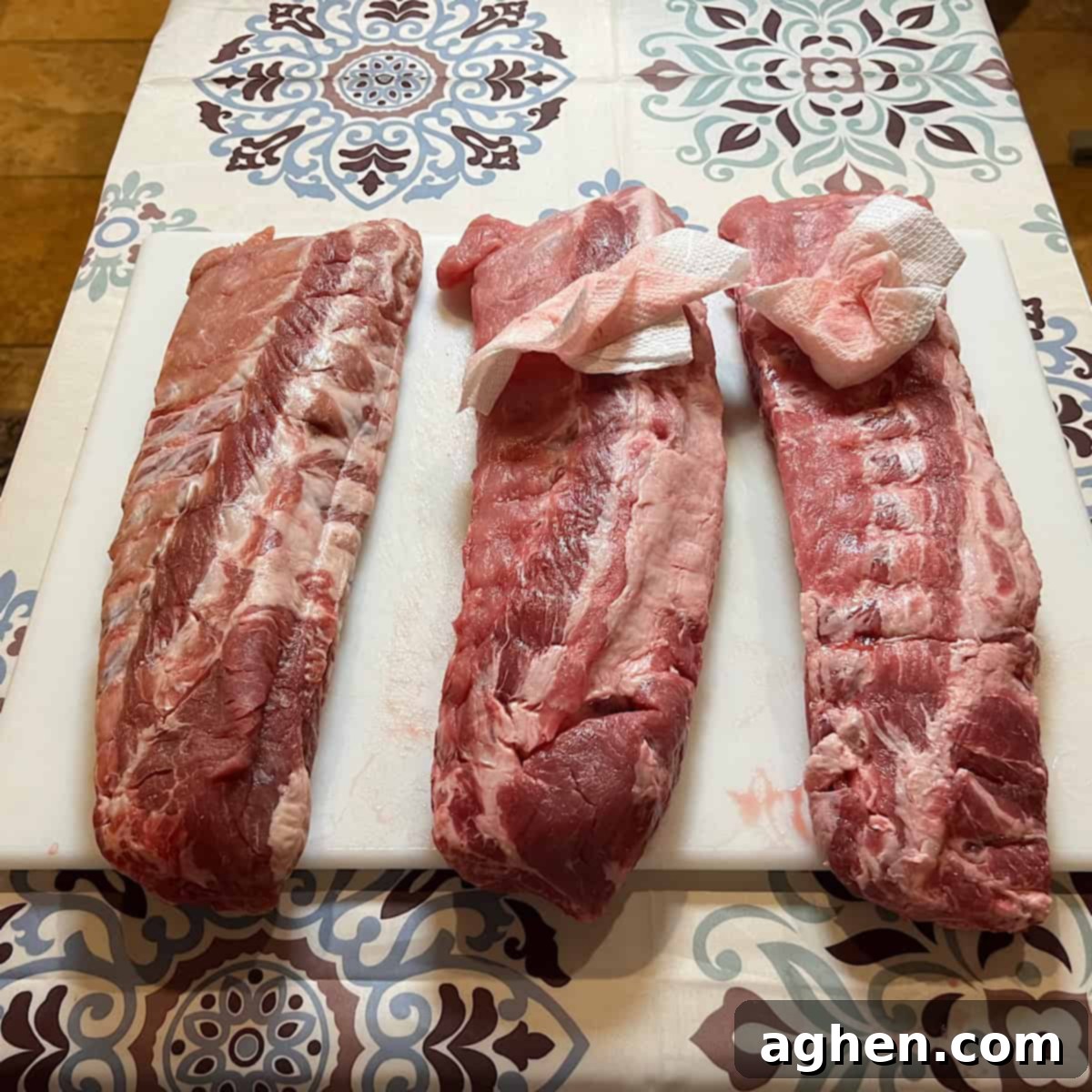 Award Winning Smoked Baby Back Ribs 3 Uncooked baby back ribs sitting on cutting board, ready for preparation.