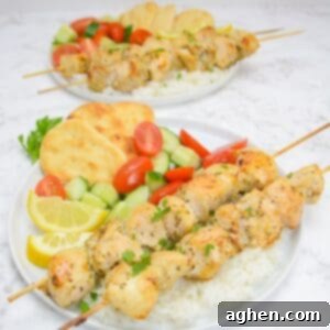 Two perfectly grilled chicken souvlaki skewers artfully arranged on a plate, ready to be served as a healthy Mediterranean meal, garnished with fresh herbs and lemon.