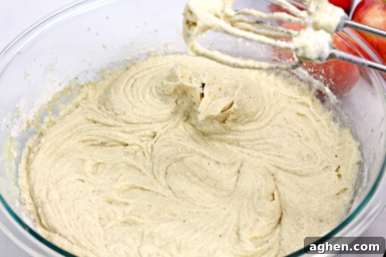 Prepared apple cider cake batter in a large mixing bowl