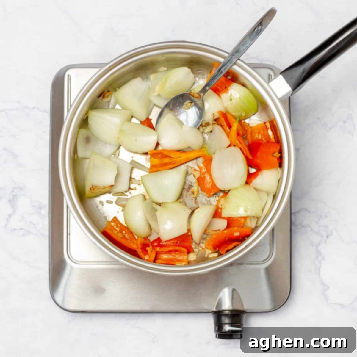 Aromatics of garlic and onions cooking in olive oil, forming the flavorful foundation of the Aji de Gallina sauce. 