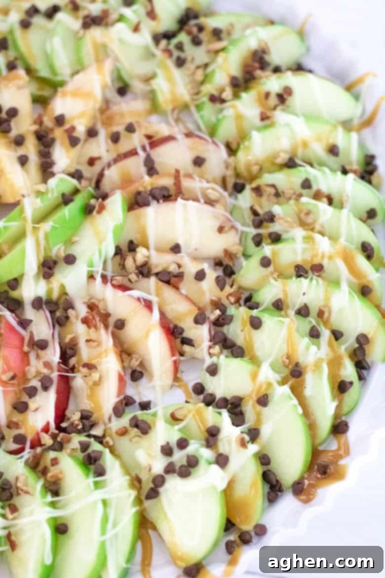 A close-up shot of a platter of freshly made caramel apple nachos, showcasing the generous toppings and vibrant apple slices.