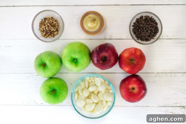 Essential ingredients for apple nachos: a vibrant selection of red and green apples, a bowl of mini chocolate chips, a pile of chopped pecans, and a squeeze bottle of rich caramel sauce.