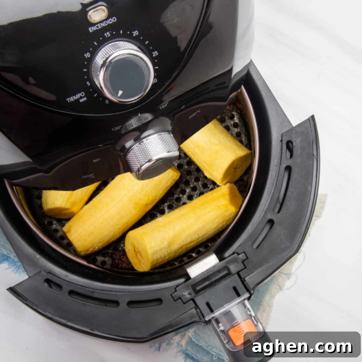 Trimmed whole plantains in an air fryer basket. 