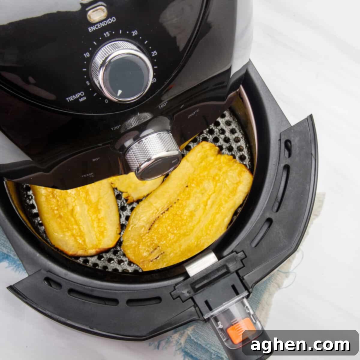 Flattened plantain slices in the air fryer basket for the final fry. 