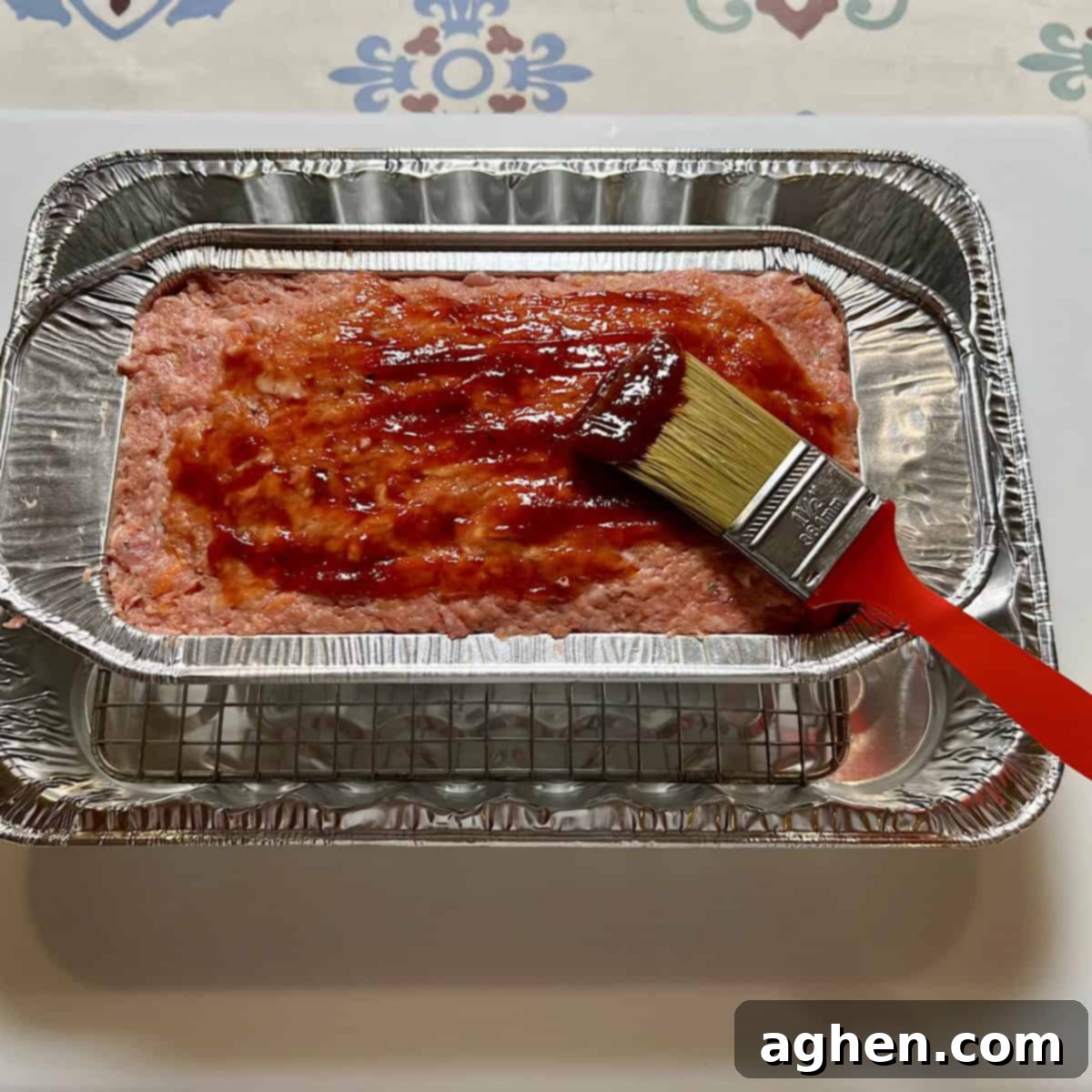The Cookout's Must-Have Smoked Meatloaf (Recipe Included!) 7 Glazing the uncooked meatloaf with BBQ sauce