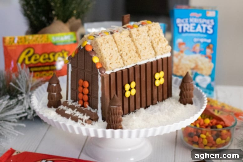 The completed candy cabin, surrounded by a realistic snowy ground made of shredded coconut, creating a cozy winter scene.