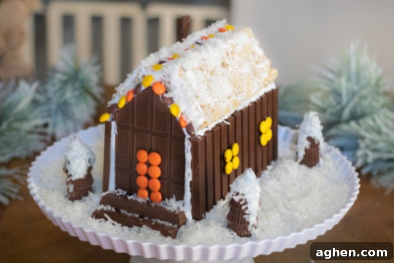 A charming Christmas candy house meticulously crafted from an assortment of chocolate treats, showcased in its full festive glory.