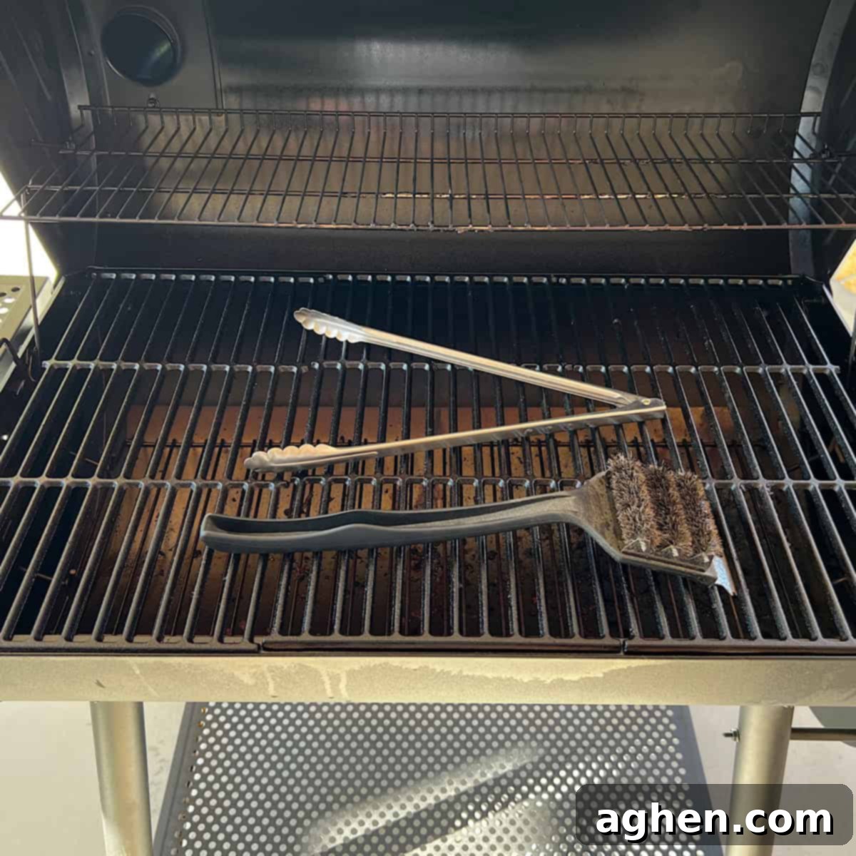 tongs and grill brush sitting on grill 