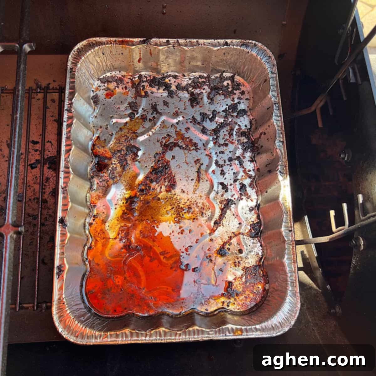drip pan full of drippings on grill 