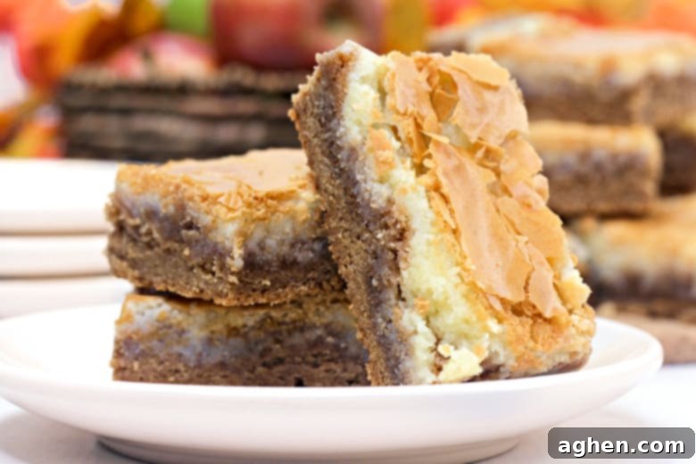 Another view of the harvest spice bars, showcasing their golden brown crust and white cream cheese layer.