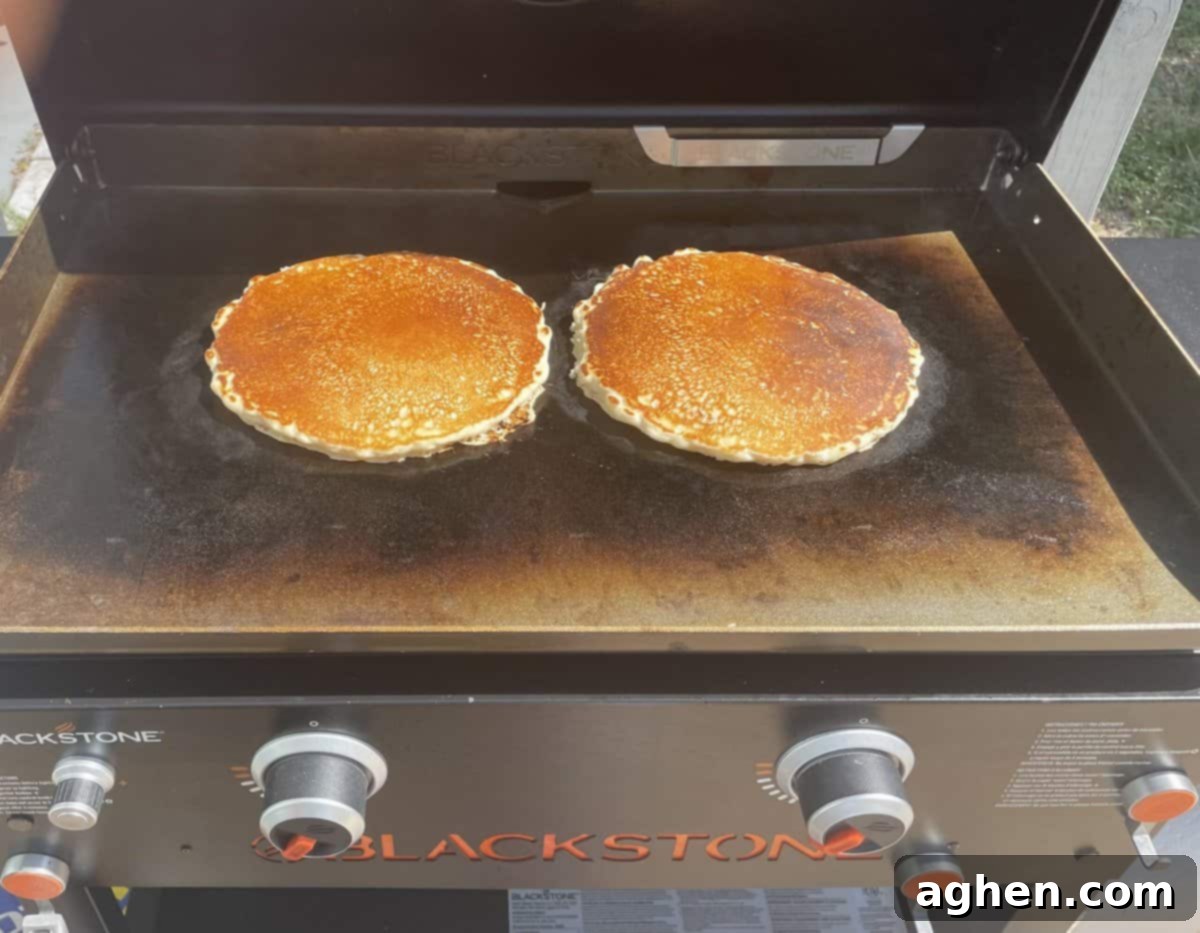 Blackstone's Jumbo Strawberry Pancakes: Every Kid's Dream 3 Two giant pancake pizzas sizzling on a Blackstone griddle