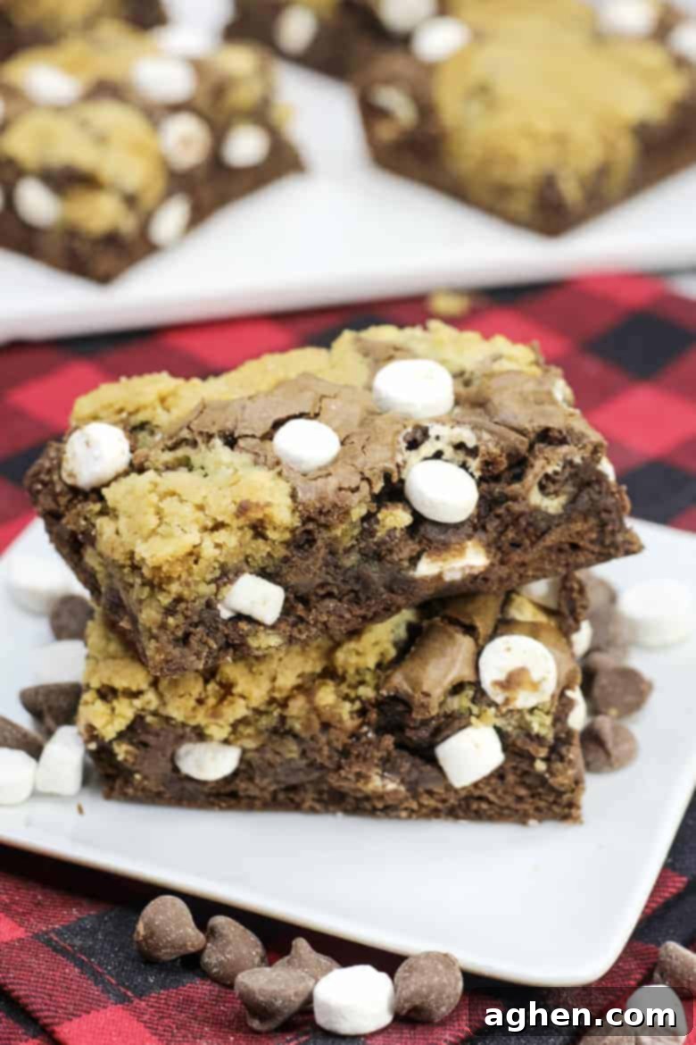 Stack of plated hot chocolate brookies ready to be enjoyed, showcasing layers of brownie, cookie, and melted marshmallows.