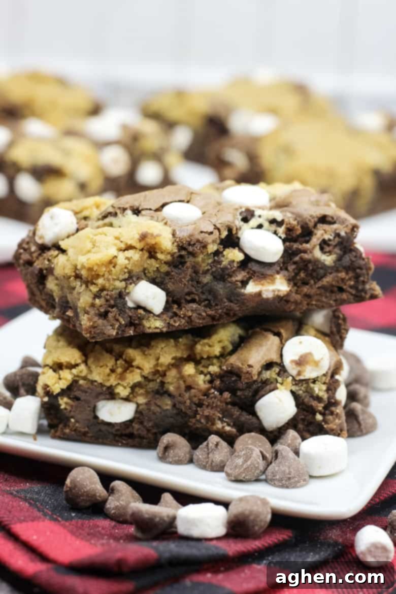 A beautifully arranged stack of hot chocolate brookies, featuring the brownie, cookie, and marshmallow layers, presented for serving.