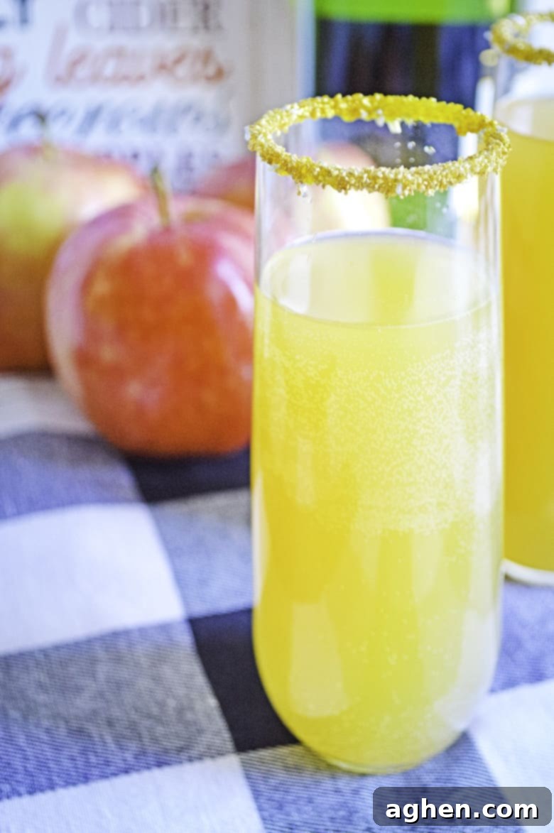 Close-up of apple cider mimosas on a table, highlighting the bubbly texture and apple garnish, inviting a taste.