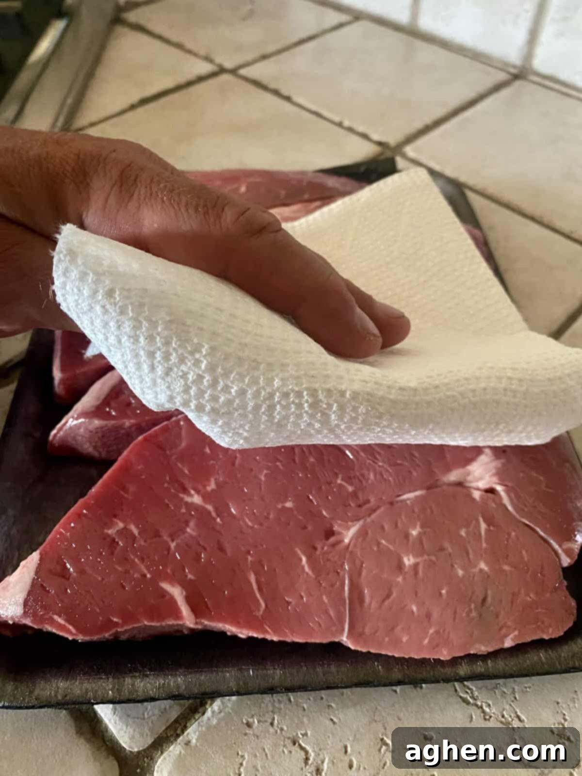 Raw steak being prepared for grilling
