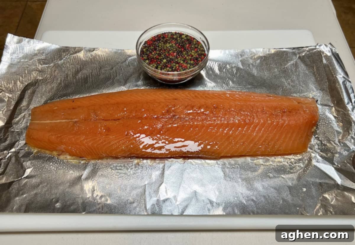 Crafting Perfect Smoked Salmon with Your Offset Smoker 8 Honey being brushed on salmon with peppercorns already applied