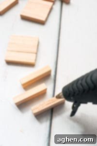 Hot glue gun applying glue to wood blocks