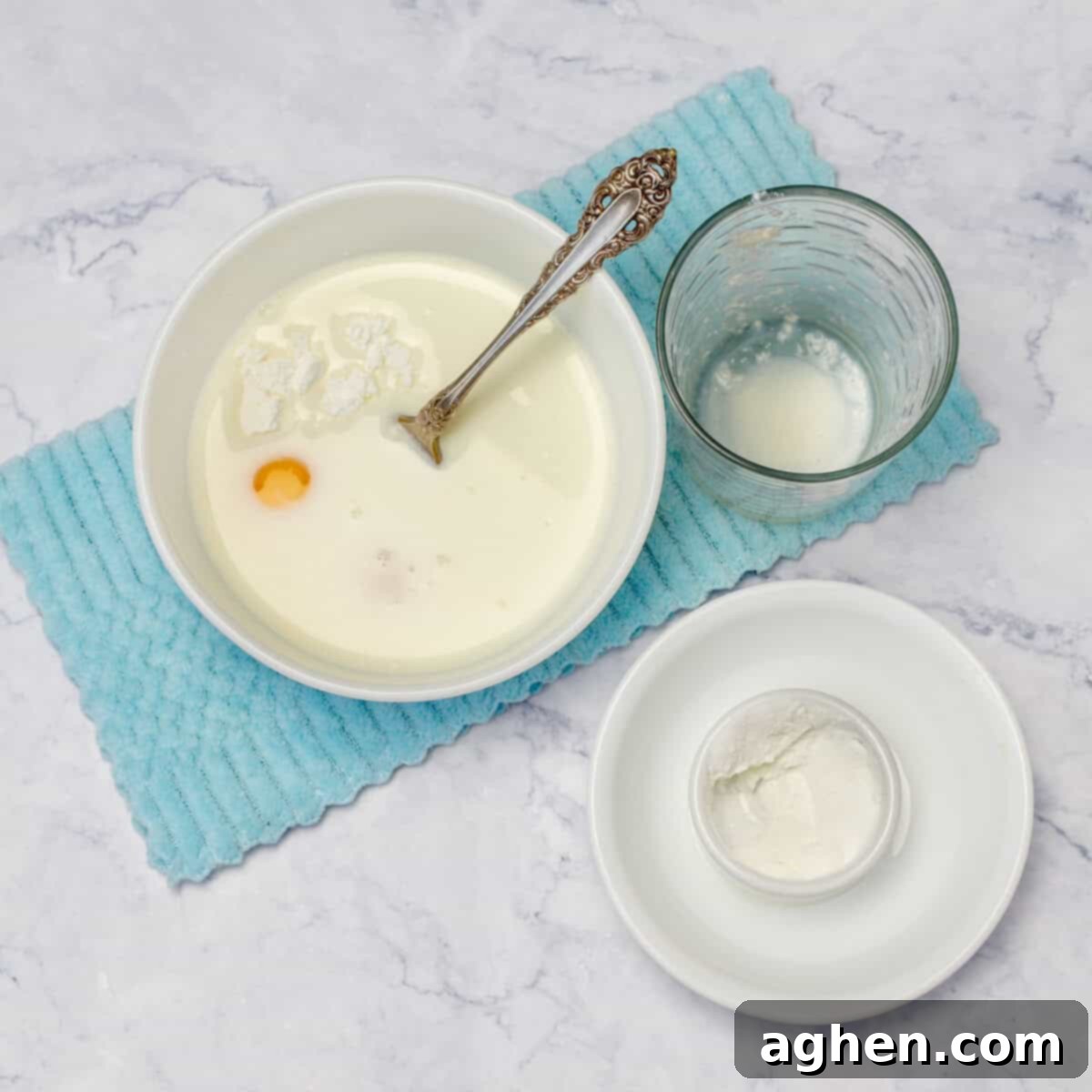 Starch, egg yolks, and skim milk being mixed into a smooth slurry in a bowl.