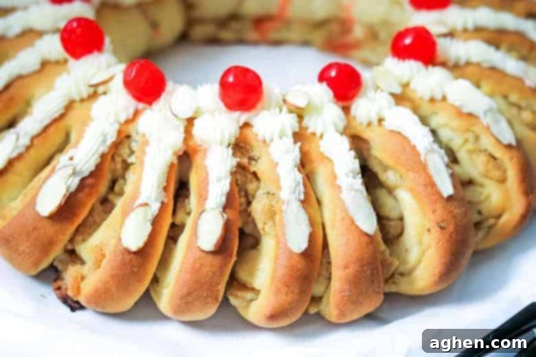 Swedish Tea Ring topped with smooth buttercream frosting, vibrant maraschino cherries, and slivered almonds, ready for serving.