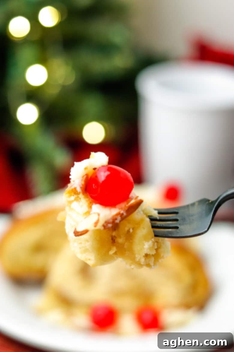 A single bite of Swedish Tea Ring on a fork, with a plated pastry and a steaming coffee mug blurred in the background, emphasizing a cozy holiday moment.