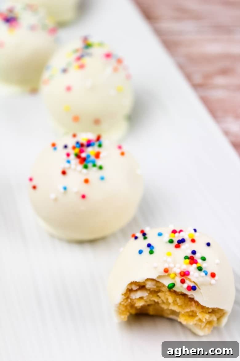 A beautifully arranged row of custom-decorated sugar cookie truffles on a festive plate.