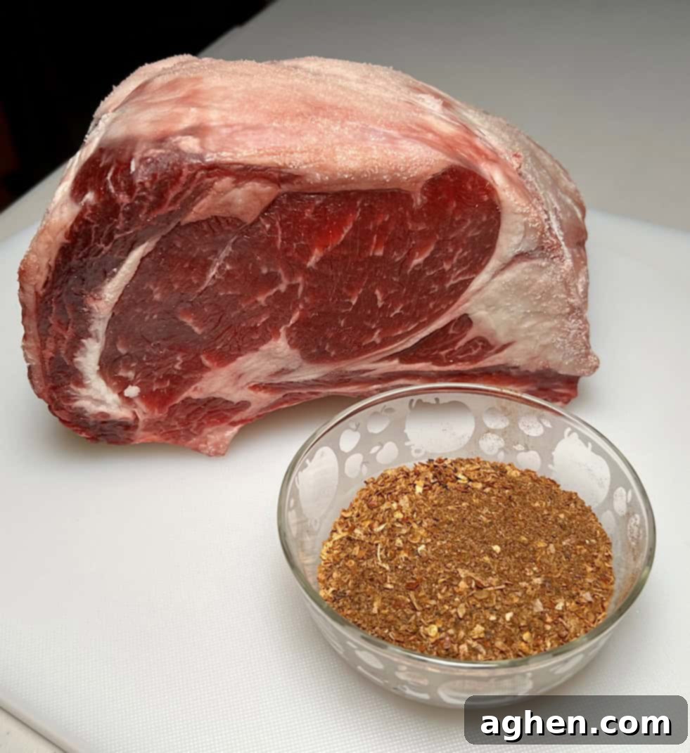 Close-up of a prime rib roast being generously coated with dry rub.