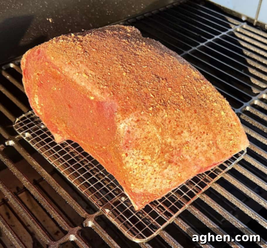Smoked prime rib roast cooking on a wire rack inside an offset smoker.
