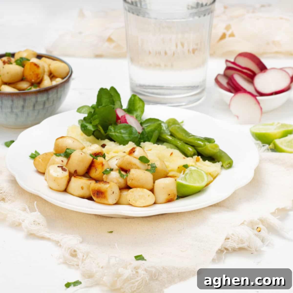 Seared scallops with lemon, garlic, and basil in olive oil on a plate with salad, showcasing a perfect golden crust.