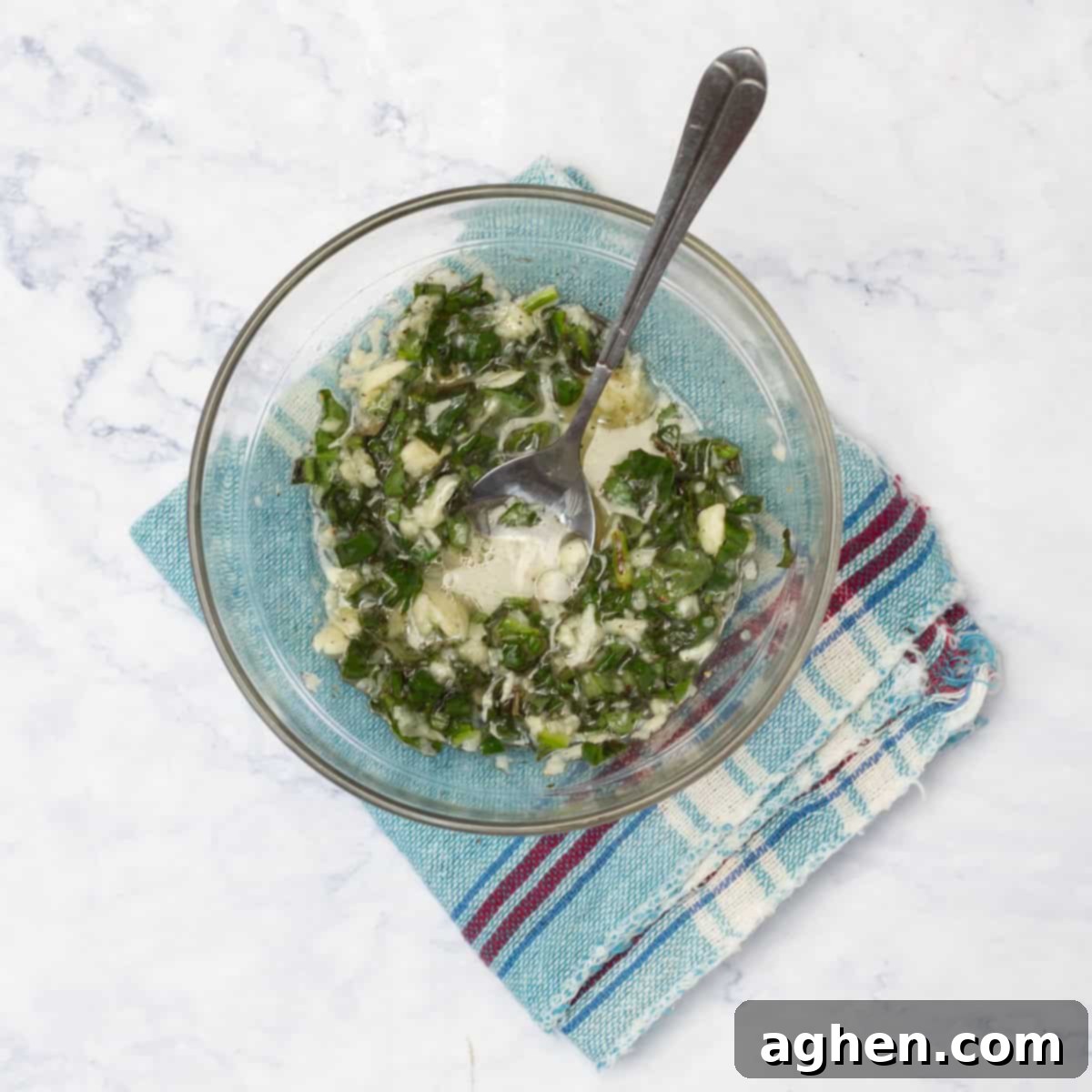 Minced garlic and chopped basil mixed in a small bowl for the scallop marinade.