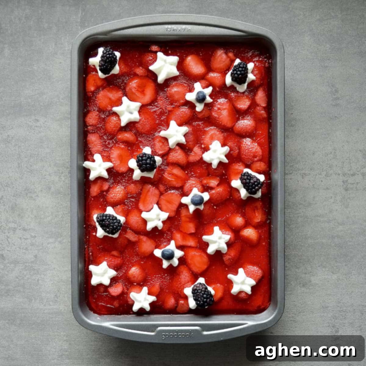 Guilt-Free 2-Point 4th of July Strawberry Pretzel Salad 2 Overhead view of a beautiful 4th of July themed jello dessert with red, white, and blue layers, garnished with fresh berries and whipped cream stars.