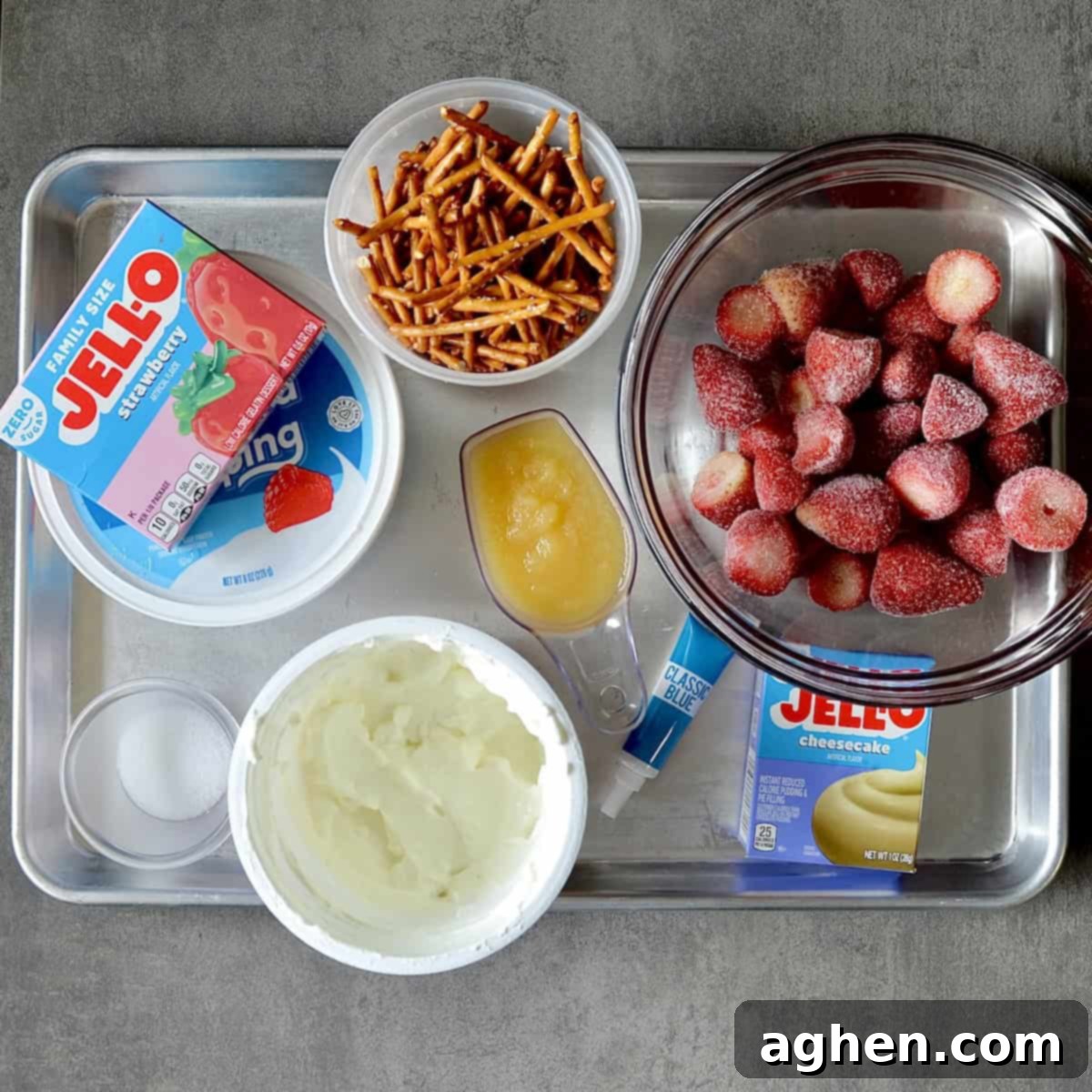 Guilt-Free 2-Point 4th of July Strawberry Pretzel Salad 3 Various ingredients laid out on a surface, including pretzel sticks, applesauce, Jello boxes, Greek yogurt, and frozen strawberries, ready for making Strawberry Jello Pretzel Salad.