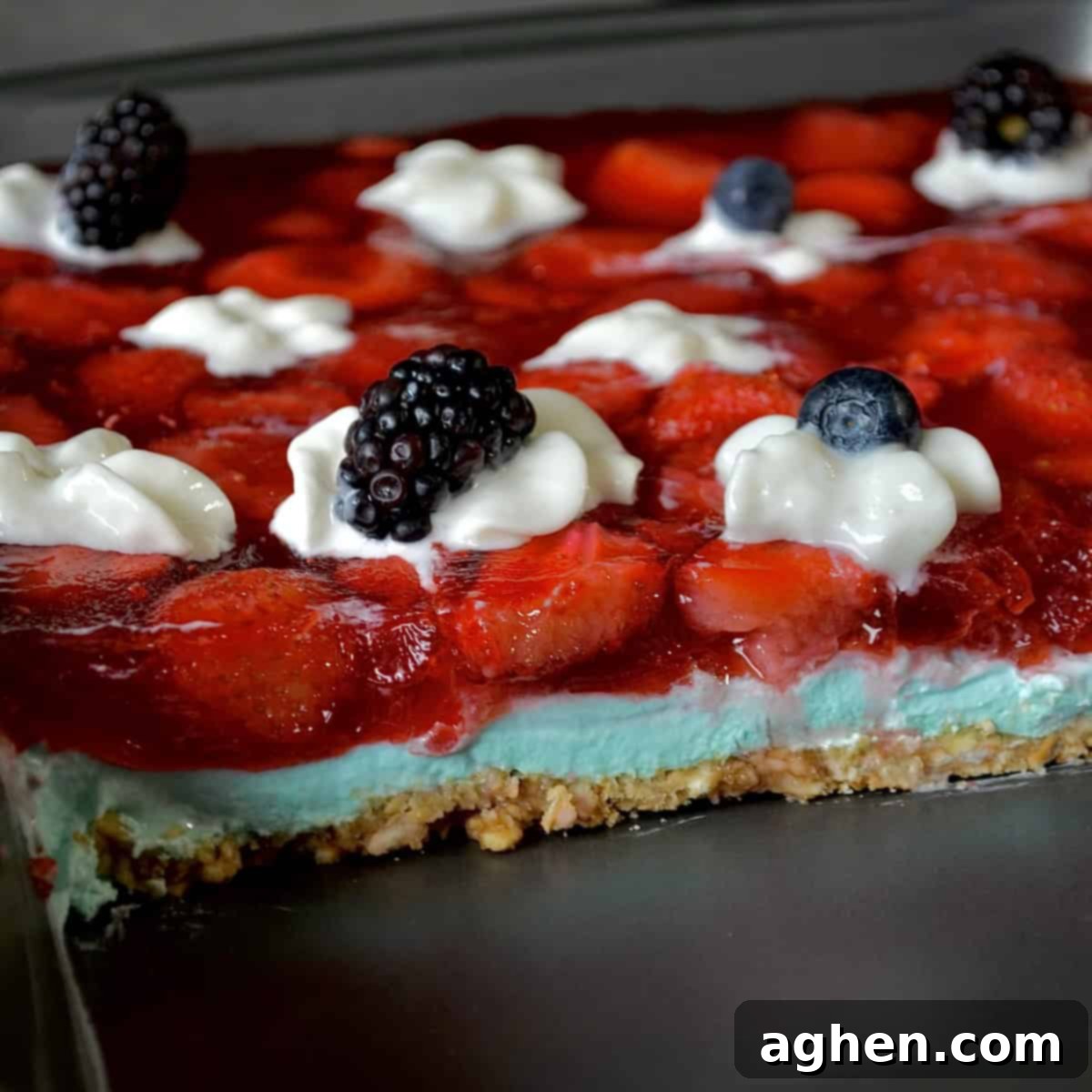 Guilt-Free 2-Point 4th of July Strawberry Pretzel Salad 6 Close-up of a finished 4th of July themed jello salad, showing distinct red, white, and blue layers, garnished with fresh berries.