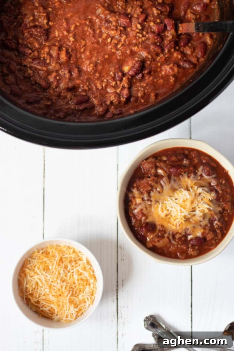 Ultimate Slow Cooker Chili 5 Bowl of chili topped with shredded cheese.