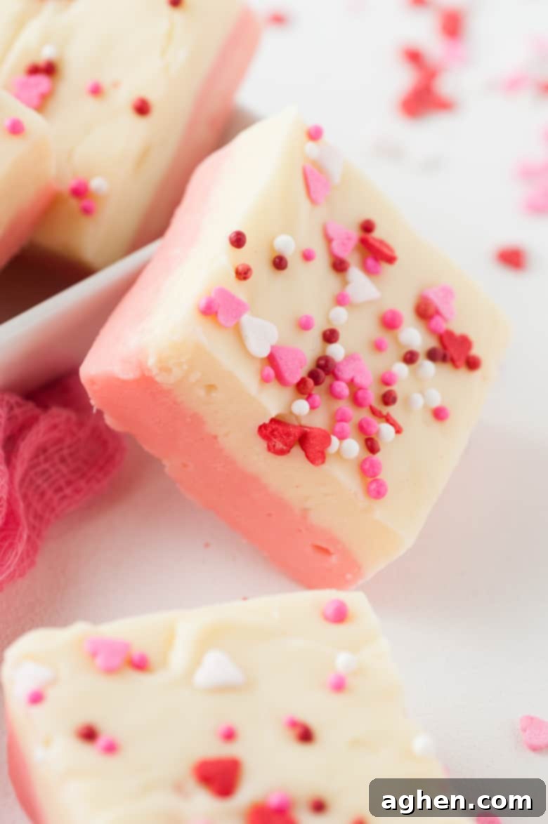 White Chocolate Valentine Fudge topped with small heart sprinkles, highlighting the vibrant colors and playful decoration.
